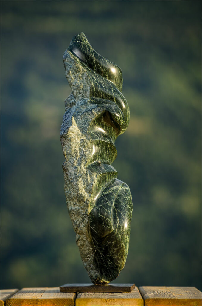 Vue de la sculpture en pierre (serpentine) Abstrait, côté gauche brut, côté droit sculpté et poli